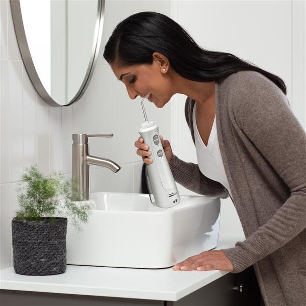 Waterpik Cordless Pearl mostrando su uso junto al lavabo