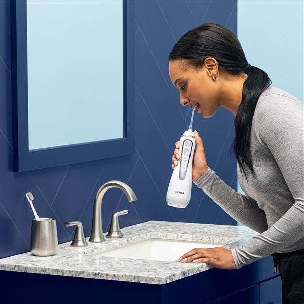 Waterpik WP-580 mostrando su uso portátil