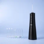 Irrigador dental portátil negro con 7 boquillas intercambiables para limpieza profunda entre dientes y encías