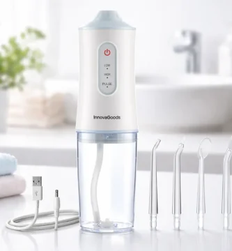 Irrigador dental portátil InnovaGoods Denter con depósito transparente y boquillas, sobre encimera de baño